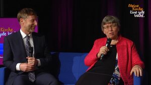 Kirchenwahl 2019: Bild zeigt Inge Schneider und Johannes Eißler im Talk auf einem blauen Sofa.